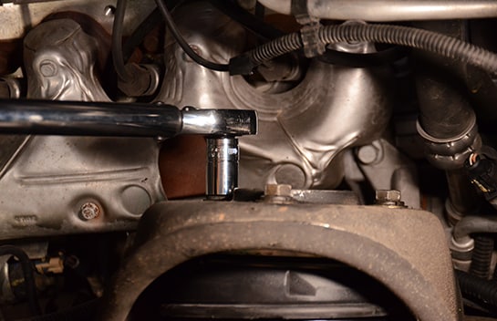 Mechanic using a ratchet to secure the nuts